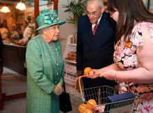 Queen learns to use self-service checkout